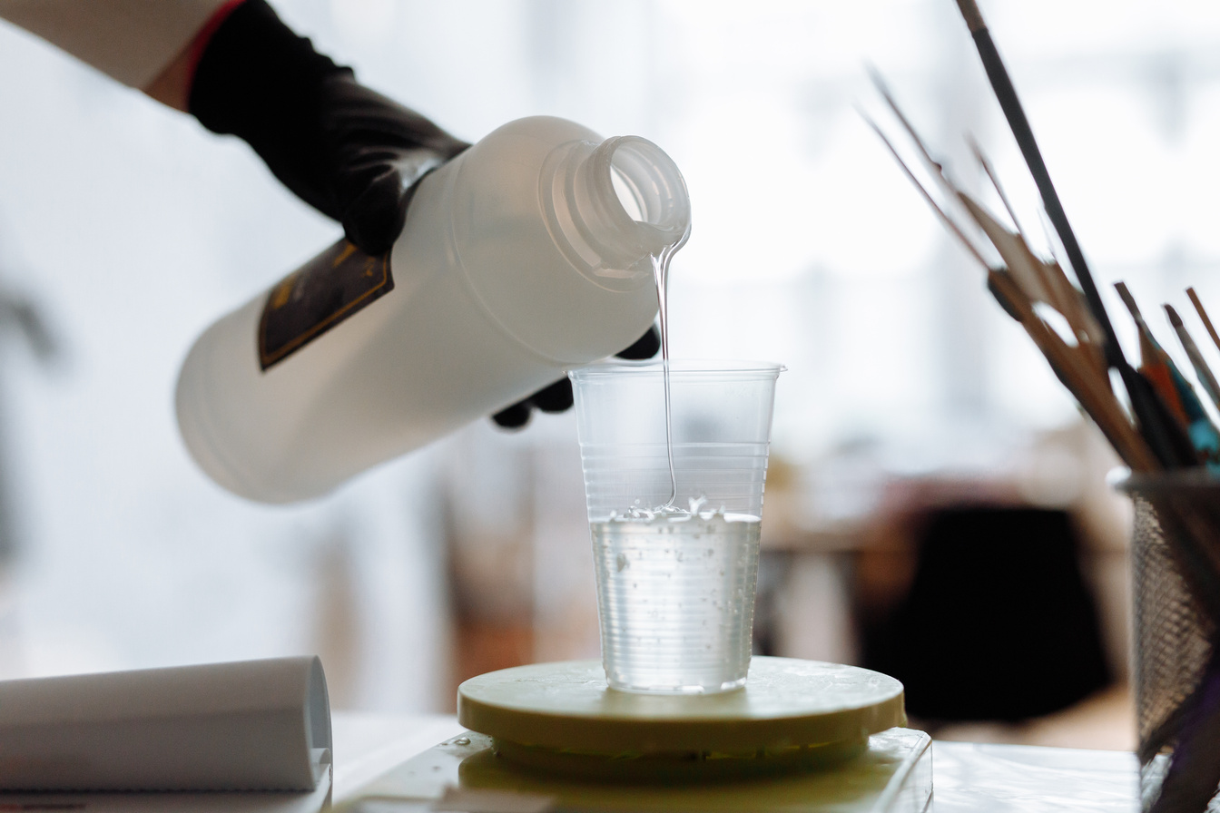 Person Pouring Resin in Plastic Cup